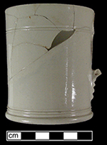 Mug with incised lathe turned decoration at base and rim. Handle terminal notched faceting detail � used by a number of Staffordshire potteries (Hilyard 2005 p. 41, 44).  Recovered from a well filled c. 1720s - c. 1750s, (Lots 2341, 2343).